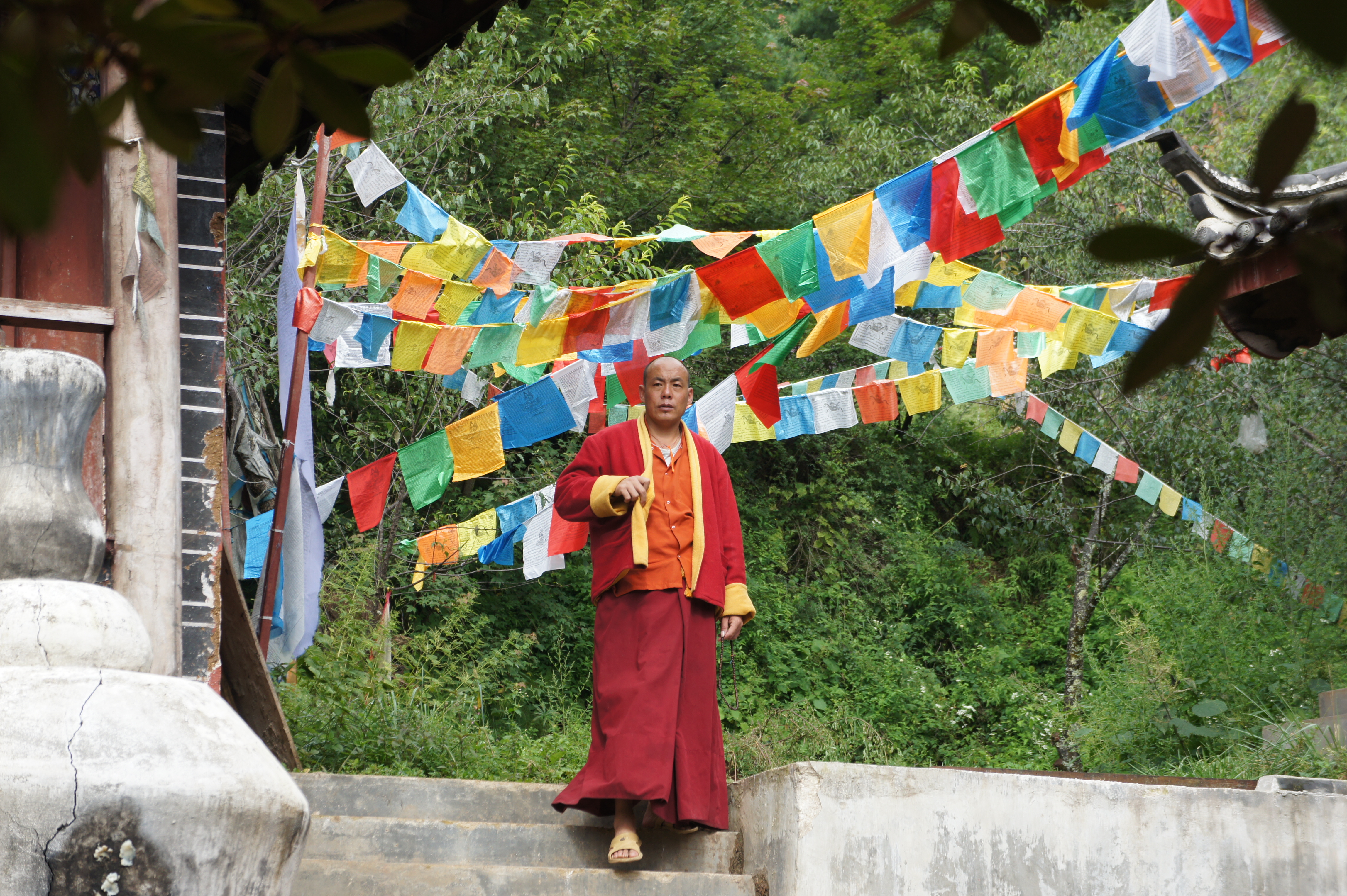 Monnik bij een klein tempeltje in de bergen